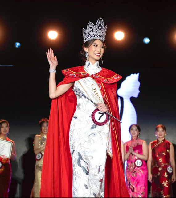 A pageant winner smiling with a crown and sash.